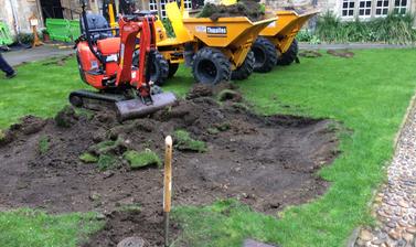 Image of teddy hall lawn being dug up by a small digger